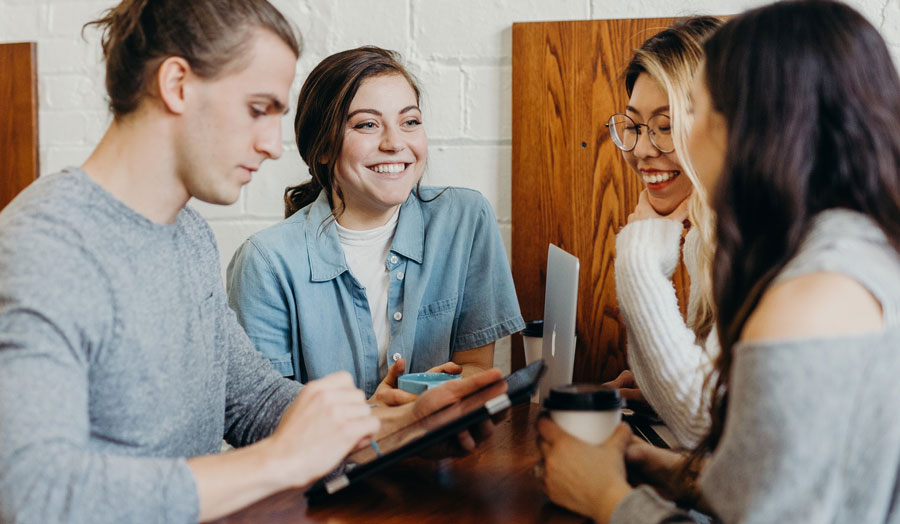 A group of friends working together at a coffee shop